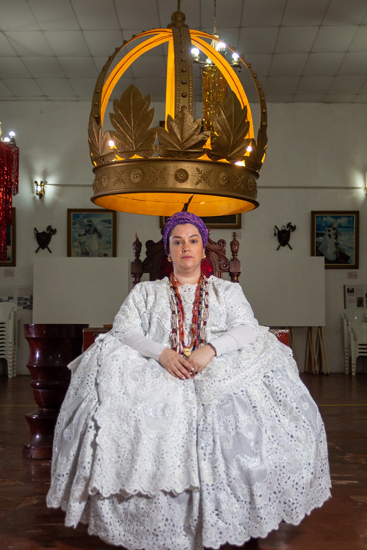Mãe Paula em frente ao Ariaxé, ponto de força do terreiro, representando pela coroa - um dos elemento de Xangô, orixá que reje o terreiro