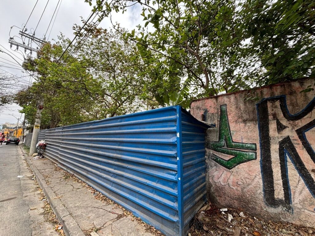 Situação atual de parte do muro após o desmoronamento com tapume metálico