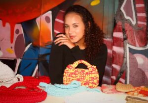 Isabella com as pochetes e bolsas de crochê que vende nos eventos e divulga nas redes sociais
